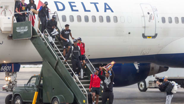 David McCormack hoists the championship trophy at Topeka Regional Airport at Forbes Field on Tuesday, April 2, 2022, as the Kansas Jayhawks men's basketball team returns from winning the NCAA men's basketball tournament . Kansas Jayhawks Return Home Champions 4